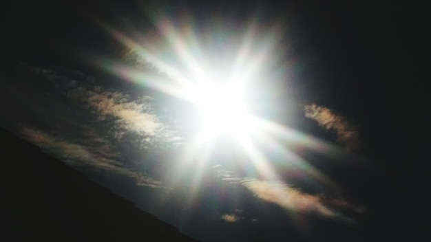 Vista de bajo ángulo del sol brillando a través de las nubes