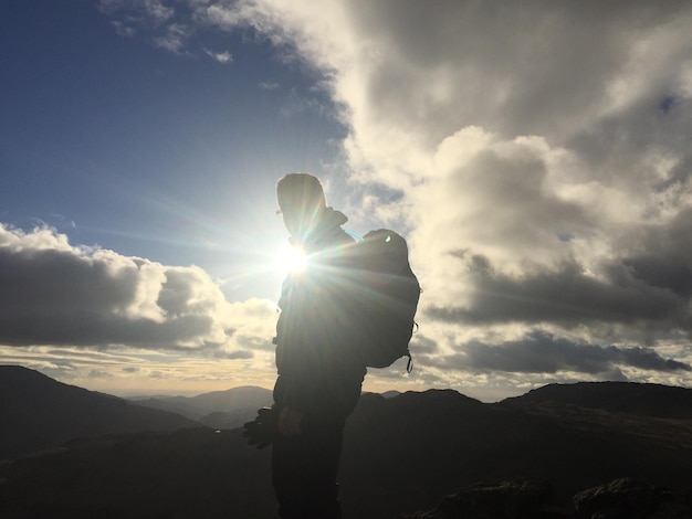 Foto vista de bajo ángulo del sol brillando a través de las nubes