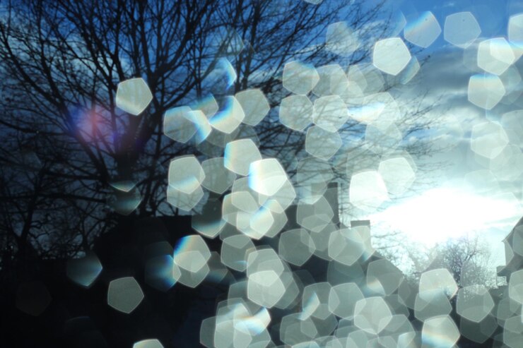 Foto vista de bajo ángulo del sol brillando a través de las nubes