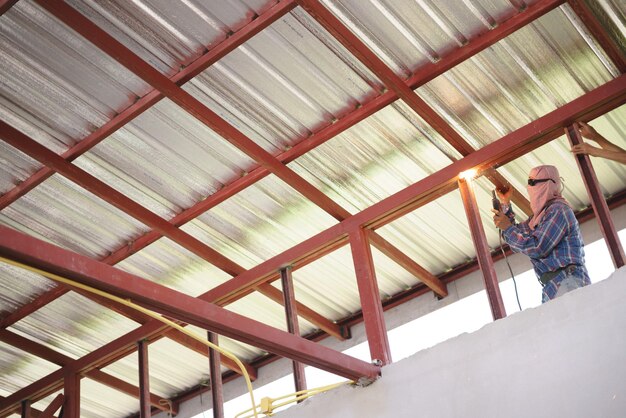 Foto vista desde un ángulo bajo de la soldadura por soldadora en el sitio de construcción