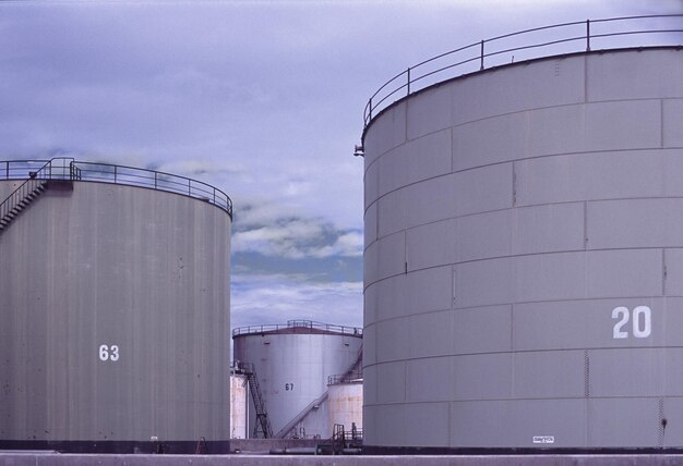 Vista de ángulo bajo de tanques de petróleo contra el cielo