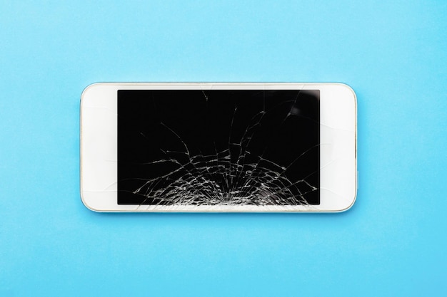 Foto vista de ángulo bajo de un teléfono inteligente sobre un fondo azul