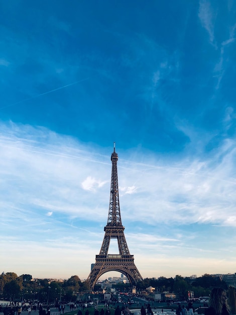 Vista de bajo ángulo de la Torre Eiffel contra el cielo azul durante la puesta de sol