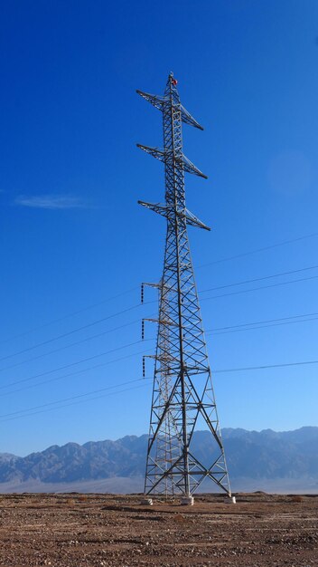 Vista de ángulo bajo de la torre de electricidad en el campo contra un cielo despejado