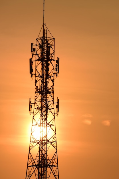 Vista de bajo ángulo de la torre de electricidad contra el cielo durante la puesta de sol