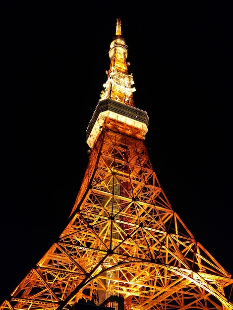 Vista de bajo ángulo de la torre iluminada de Tokio contra el cielo en la ciudad por la noche