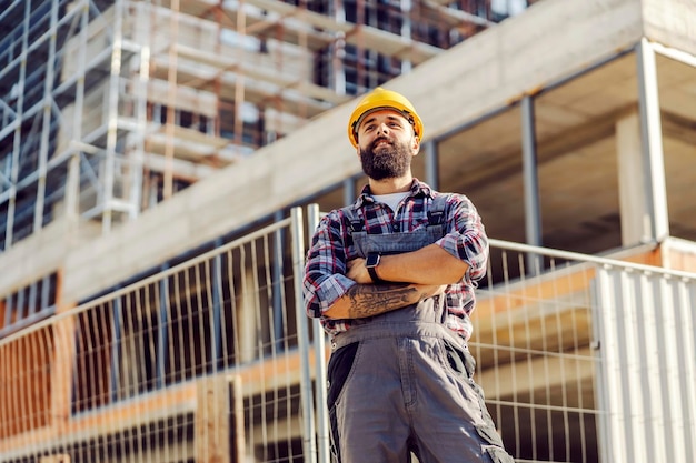 Vista de ángulo bajo de un trabajador orgulloso en el sitio de construcción