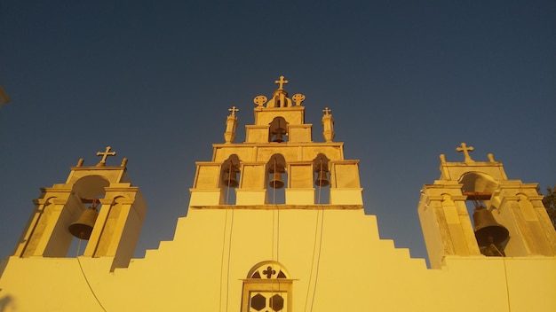 Vista de bajo ángulo de la vieja iglesia contra un cielo despejado durante la puesta de sol