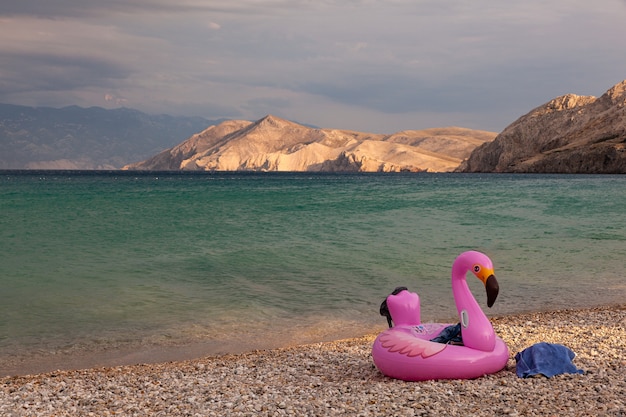 Vista de un anillo inflable de natación con diseño de flamencos en la playa de Baska, Croacia