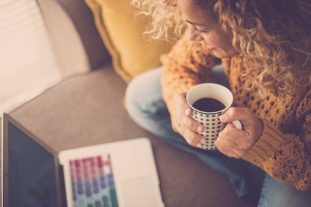 Vista anterior de la hermosa mujer de mediana edad caucásica mirando la computadora portátil con gráficos de negocios en la pantalla