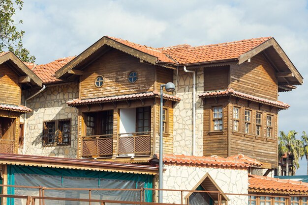 Vista de la antigua casa antigua con techo rojo y árboles junto al mar en Turquía. Side es un destino turístico más popular en Turquía.