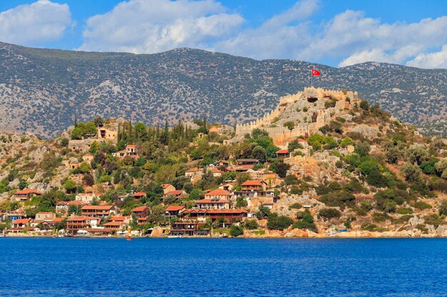 Vista de la antigua ciudad licia de Simena con una fortaleza en un monte en la costa del mar Mediterráneo en la provincia de Antalya, Turquía