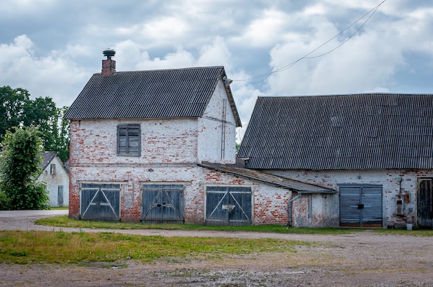 Vista del antiguo granero de ladrillo abandonado en verano.