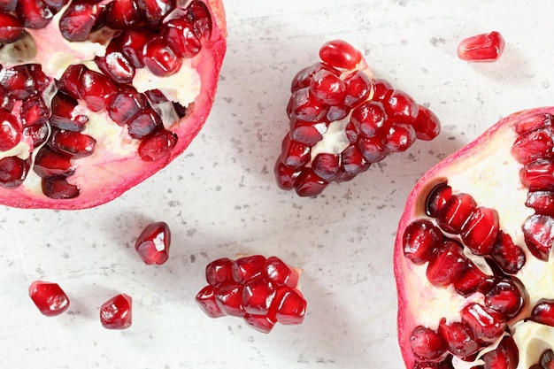 Vista aproximada da mesa - metade de romã, cachos de gema como frutas espalhadas no quadro branco.