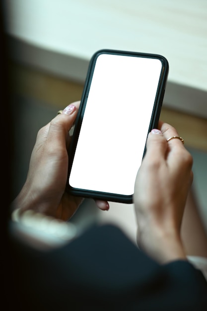 Vista aproximada das mãos da mulher segurando o celular Tela branca para o seu texto de anúncio