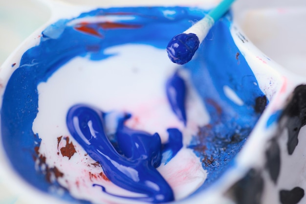 Vista aproximada de uma pintura de paletes de cores com tinta azul e preta