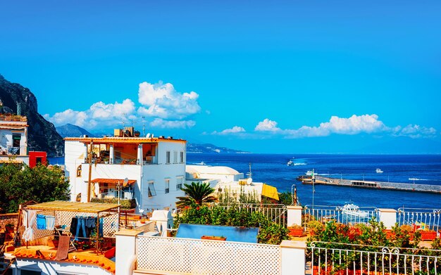 Vista con arquitectura de villas en la isla de Capri en Nápoles en Italia. Paisaje con barcos y yates en el mar Mediterráneo en la costa italiana. Anacapri en Europa en verano. Paisaje de Amalfi en la montaña Solaro