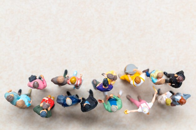 Vista de arriba hacia abajo de un grupo de personas en miniatura que muestran diferentes ropas y poses
