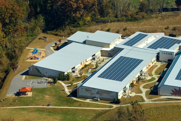 Vista desde arriba del campus de una escuela estadounidense con techo cubierto con paneles solares fotovoltaicos para producir energía eléctrica limpia