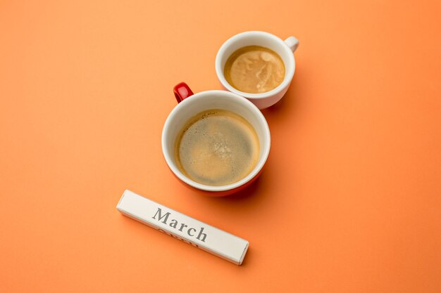 Vista desde arriba con espacio de copia. Fondo para el día de la mujer, 8 de marzo. Mesa naranja. Mujer y lugar de trabajo estilizado. 8 de marzo y concepto del día de la mujer.