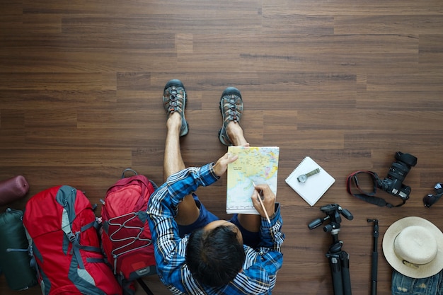 Vista de arriba del plan de hombre viajero con mapa de tenencia