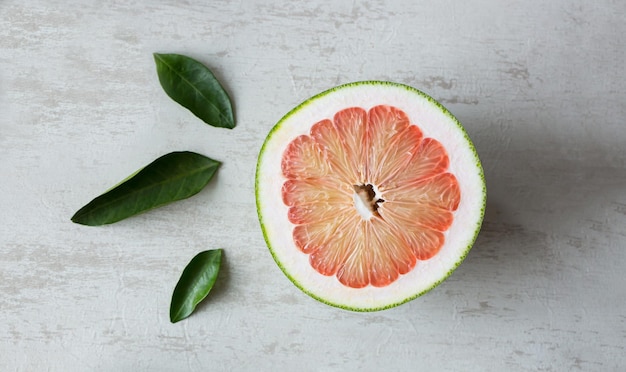 Vista de arriba de un pomelo jugoso decorado con hojas