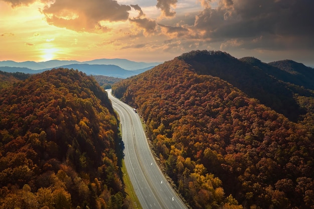 Vista desde arriba de la ruta de la autopista I40 vacía y desierta en Carolina del Norte que conduce a Asheville a través de las montañas Apalaches con bosques amarillos otoñales Concepto de transporte interestatal