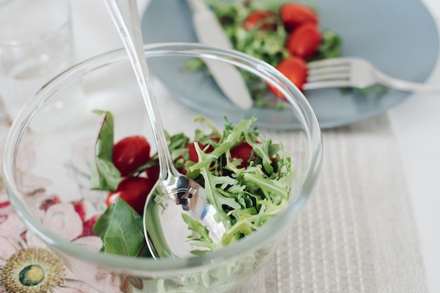 Vista desde arriba de tomates y verduras saludables en placa gris en la cocina. Sabrosas verduras frescas, cuchillo y tenedor en mesa de café. Concepto de cocina, dieta y nutrición.