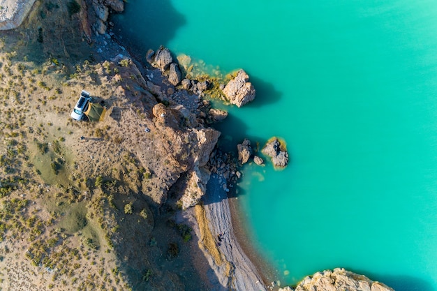 Vista desde arriba, vista desde el aire al mar esmeralda con la playa y turistas en coche