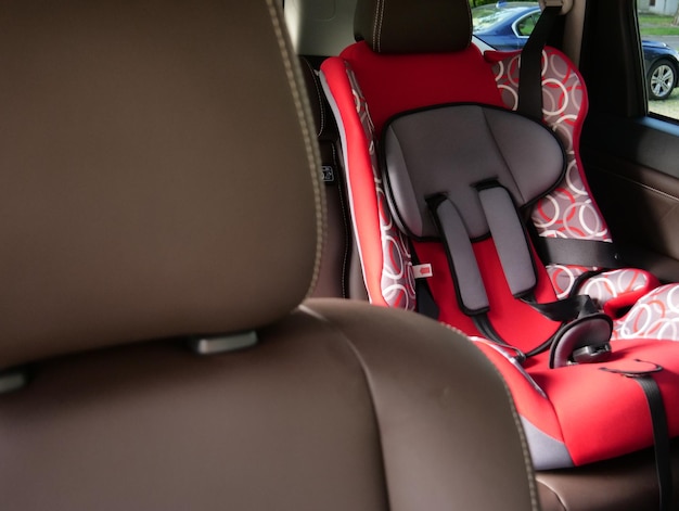 Foto vista desde el asiento del pasajero delantero hasta el asiento de coche para niños en la fila trasera de los asientos de coche