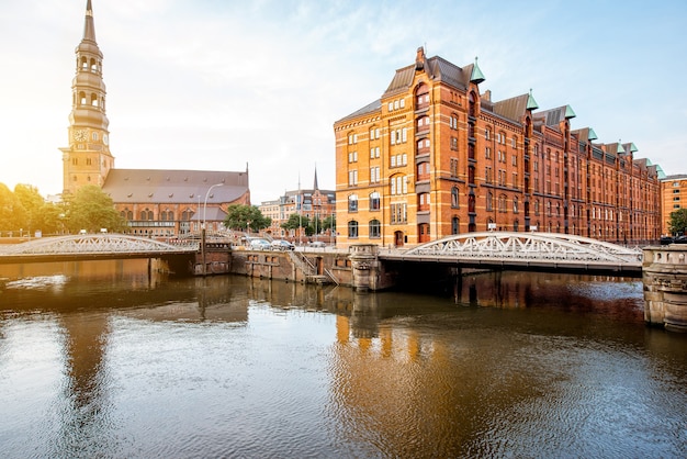 Vista del atardecer en el casco antiguo con la iglesia de Santa Catalina y el distrito de Hafen con almacenes en la ciudad de Hamburgo, Alemania.