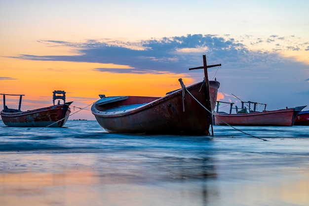 Vista del atardecer con cielo nublado en la playa de Gadani con barco dhow