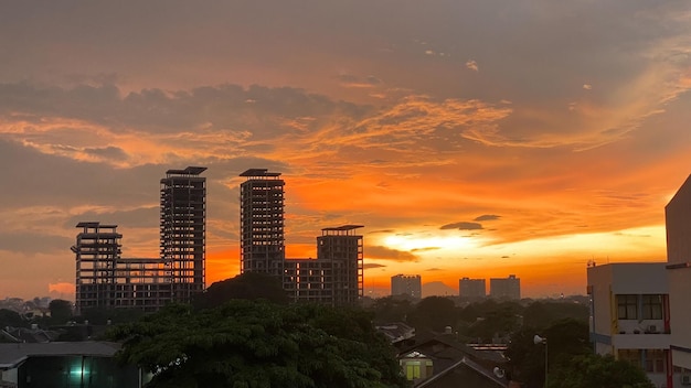 Una vista del atardecer de una ciudad con un edificio en primer plano