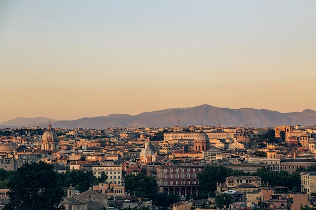 Una vista del atardecer de Roma desde la colina con montañas al fondo