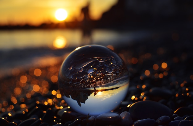 Foto vista del atardecer a través de los ojos de la esfera de lensball.