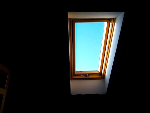 Vista de un ático oscurecido durante el día en un cielo azul sin nubes con un espejo a la izquierda