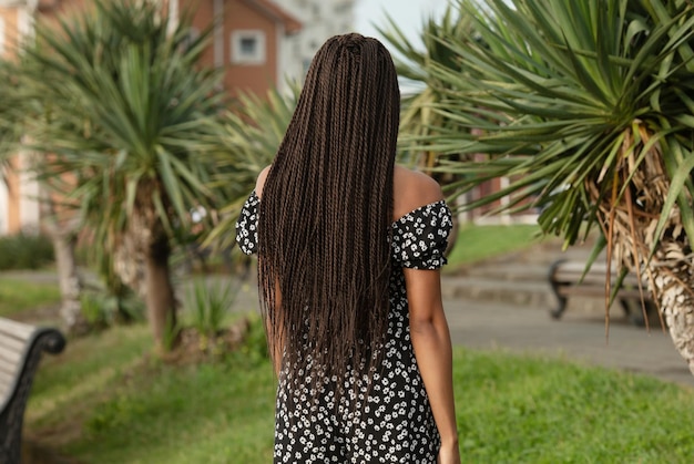 Vista desde atrás de una chica con rastas negras de kanekalon.