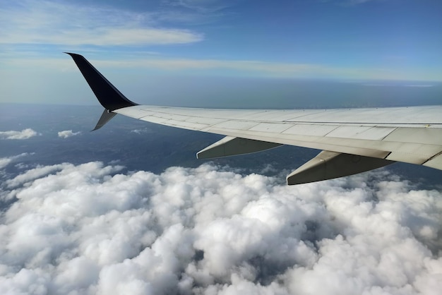 Vista através da janela do avião da asa do avião a jato comercial voando alto no céu Conceito de viagem aérea