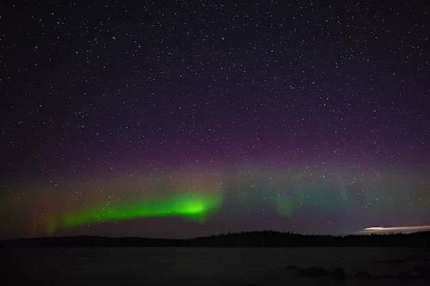 Vista de la aurora boreal. Luces polares en el cielo estrellado de la noche sobre el lago.