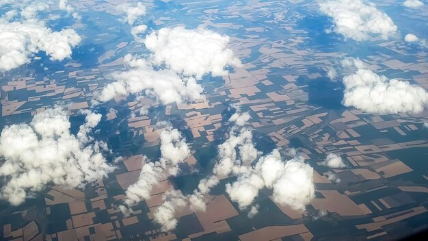 Vista desde el avión sobre las nubes volando sobre los campos.