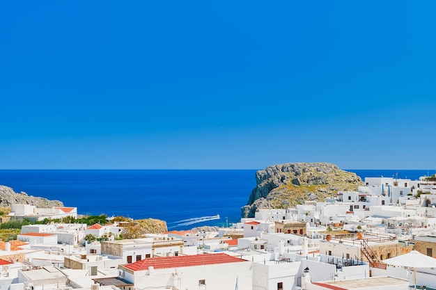 Vista de la azotea de la ciudad de Lindos y el mar esmeralda con barcos que pasan Isla de Rodas Islas griegas del archipiélago del Dodecaneso Vacaciones en Europa y destino turístico popular