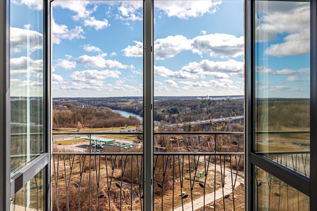 Vista desde el balcón al río y al área industrial con cielos azules y nubes