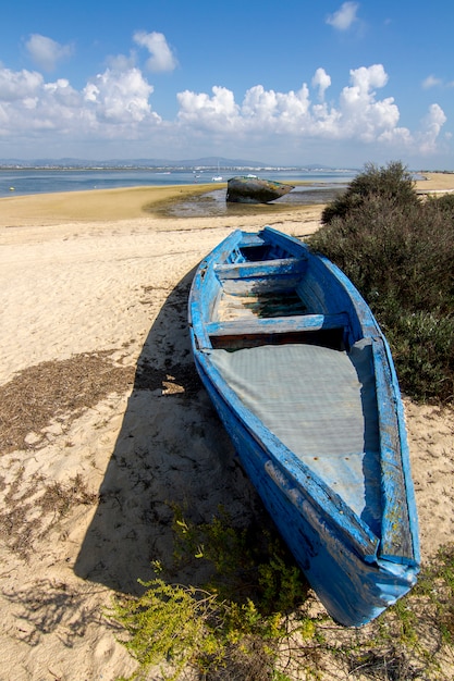Vista de un barco abandonado viejo trenzado en la arena seca en la playa.