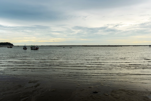 Vista de los barcos de pesca amarrados en la orilla del mar en la noche, foto de larga distancia, hermoso paisaje