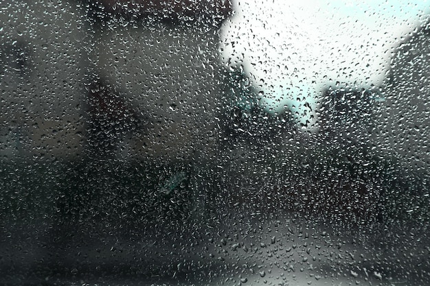 Vista borrosa de la calle de la ciudad desde la ventana en un día lluvioso