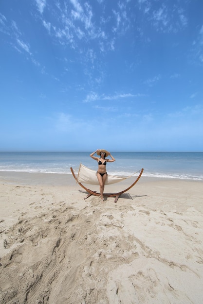 Vista de buenas chicas balanceándose en montículo en la playa del mar