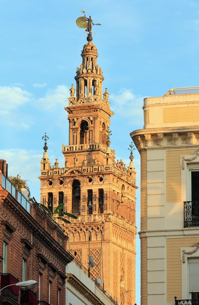 Vista de la calle de la ciudad de Sevilla por la noche y el campanario de la Giralda, España. Construido en 1184-1198.