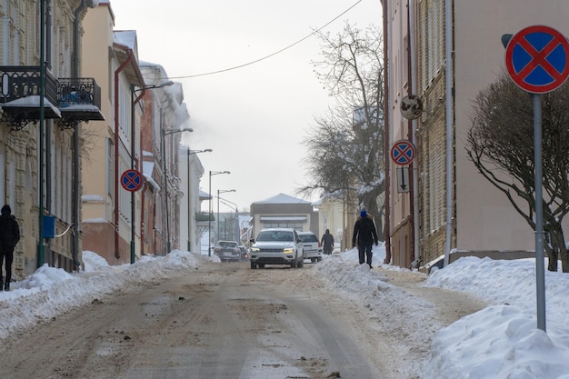 Vista de una calle estrecha cubierta de nieve después de una nevada La calzada está cubierta de nieve y hielo El coche se quedó atascado en la carretera a causa del hielo