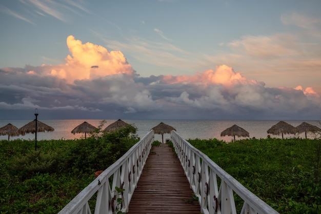 Vista de un camino de madera que conduce a la playa de arena en el Mar Caribe en Cuba