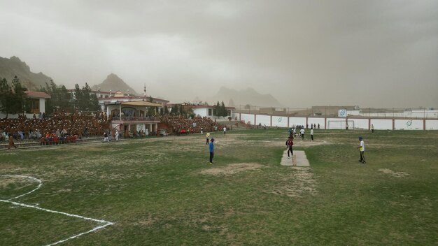 Una vista de un campo de deportes con algunas personas jugando al cricket